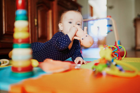 女婴在地板上玩玩具。 快乐健康的小孩在家