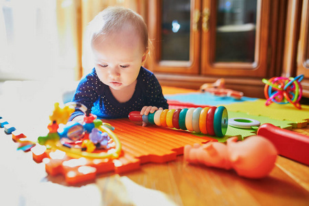 女婴在地板上玩玩具。 快乐健康的小孩在家