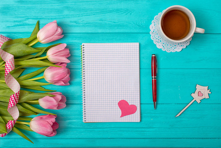 s Day background with bouquet of tulips and an empty notebook fo