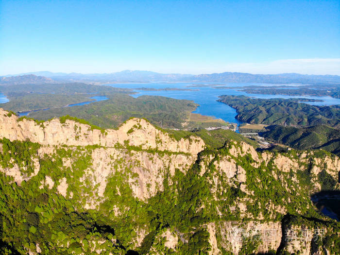 背景上有水库的山的鸟瞰图山顶有美丽的蓝天和绿色的森林自然保护区