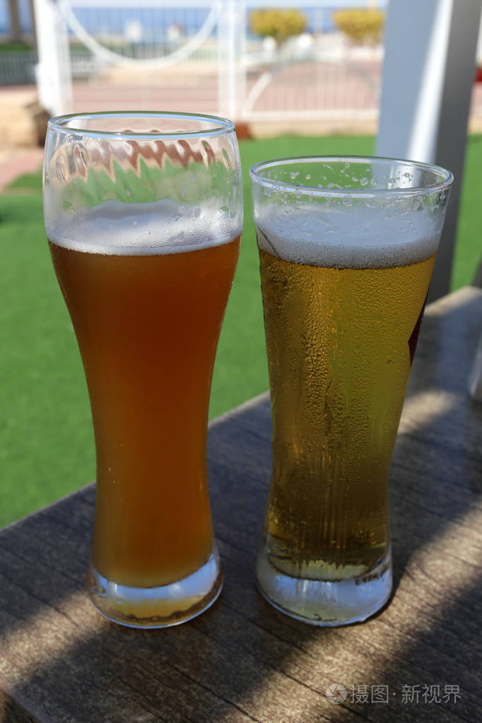 在桌子上的一家餐馆里喝着一杯冰镇啤酒