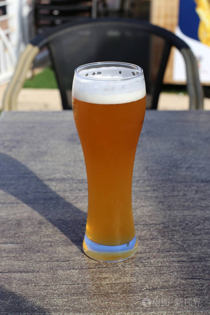 在桌子上的一家餐馆里喝着一杯冰镇啤酒