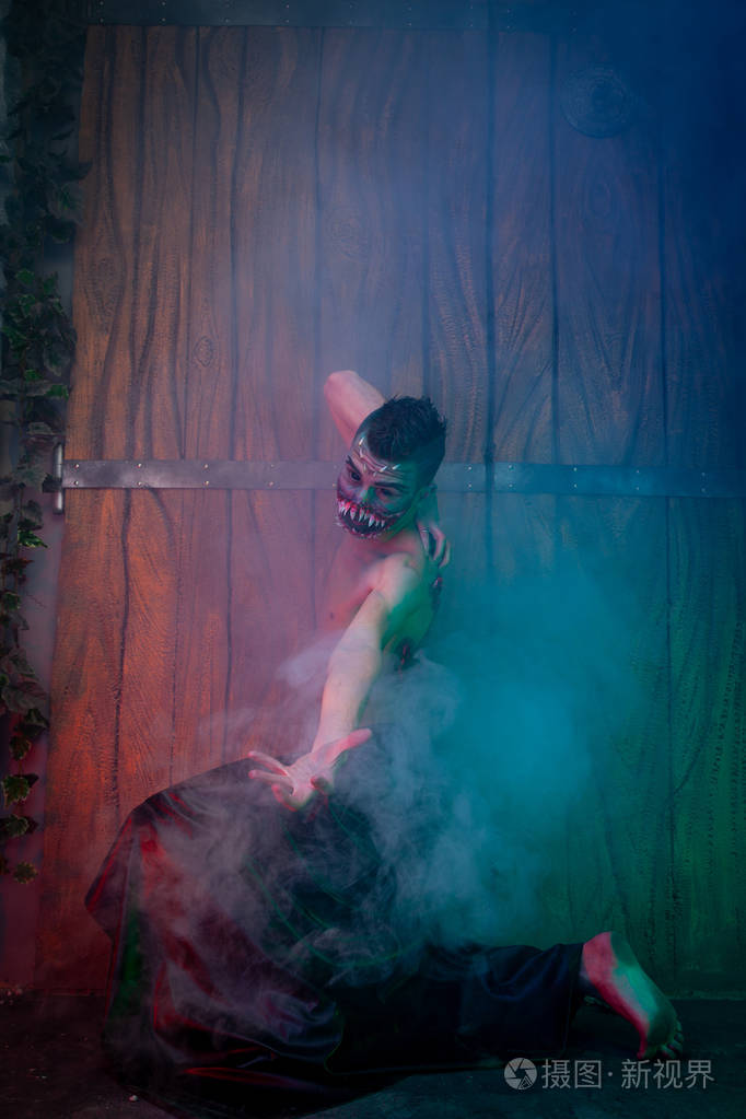 可怕的吸血鬼男性,巨大的牙齿和血腥的身体作为万圣节的身体艺术,独自