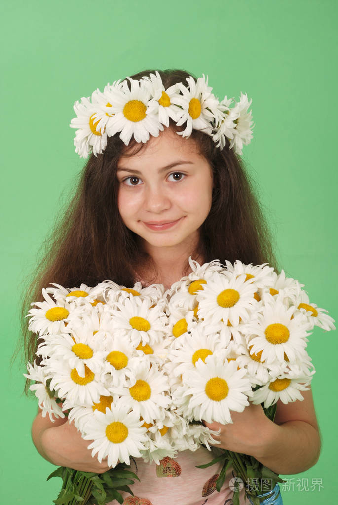 绿色背景上有洋甘菊花环的漂亮女孩