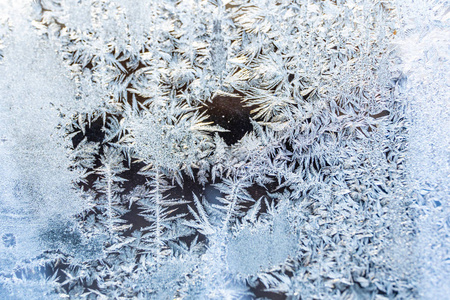 特写照片在阳光明媚的冬日窗户上的海霜细节抽象背景与图案