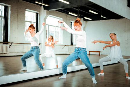 红头发的芭蕾老师和她的学生在舞蹈工作室里感觉很棒