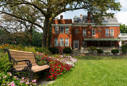长凳和花园与历史上的埃尔伍德房子的背景. 伊利诺伊州,美国照片