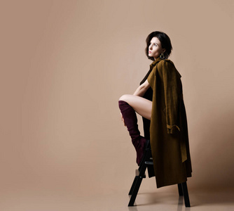 年轻美丽的嬉皮士女孩坐在的内衣, 棕色春天夹克和现代时尚皮靴思考