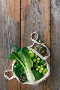 健康食品与织物生态袋水果和蔬菜。木制桌上观景平台的素食或素食食品