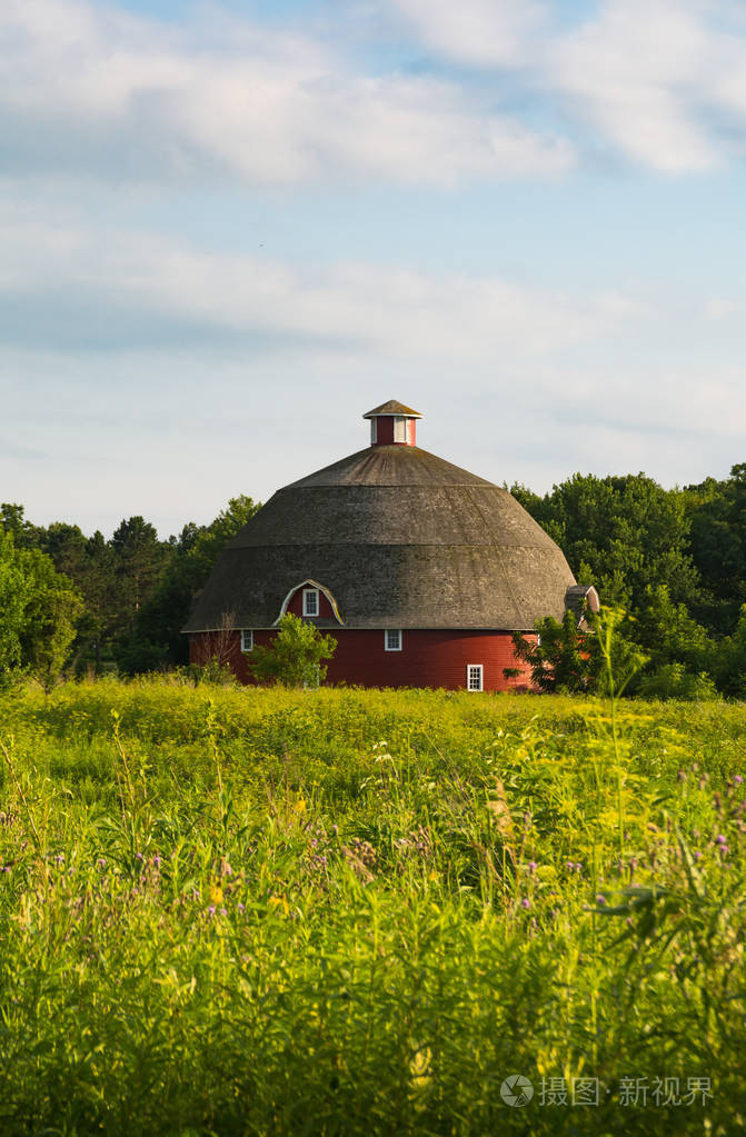 圆形的红色谷仓有草地和美丽的天空美国伊利诺斯州基瓦尼