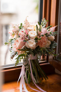 粉红色和桃子婚礼花束站在窗台上