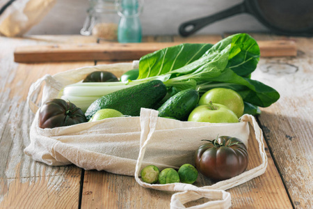 健康食品与织物生态袋水果和蔬菜。 木制桌子上的素食或纯素食物