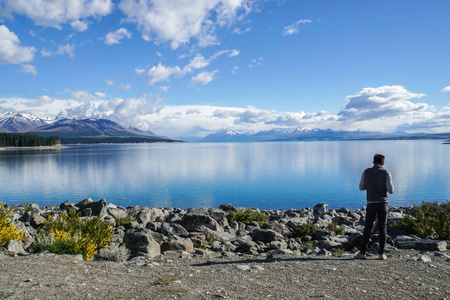 户外男子，有清澈的蓝色湖泊和山脉，新西兰