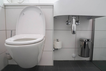 现代浴室内部白色陶瓷马桶和洗脸盆水槽与不锈钢垃圾桶