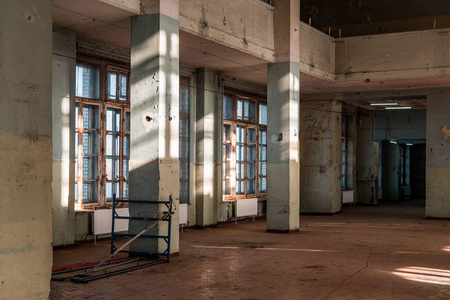 苏联工厂的旧废弃建筑。 有柱子的空房间。 日光