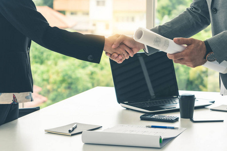 商人高管与现代职场办公室的女商人握手. 人们企业经营的概念.照片