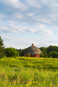 圆圆的红色谷仓，有草地和美丽的天空。 美国伊利诺伊州