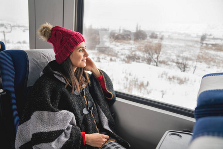坐在火车上, 透过大窗户看的年轻女旅行者