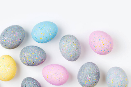 背景为淡粉色蓝色黄色和灰色复活节彩蛋
