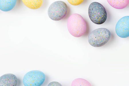 背景为淡粉色蓝色黄色和灰色复活节彩蛋