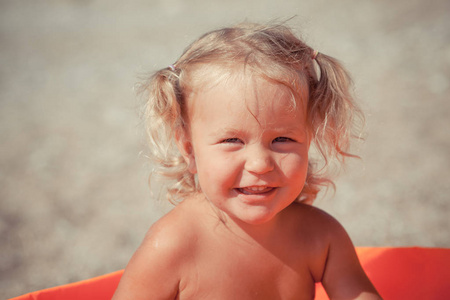 漂亮的小女孩在海边玩游泳池玩具