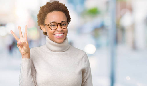 年轻美丽的非裔美国妇女戴着眼镜，在孤立的背景上，用手指第三，同时微笑，自信和快乐。
