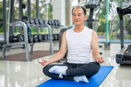 老年人在健身健身房练习瑜伽。 成熟健康的生活方式。