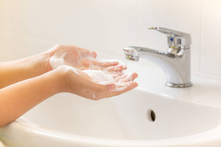 在浴室洗手池里用泡沫洗手