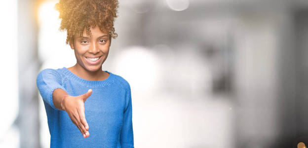 美丽的年轻非洲裔美国妇女在孤立的背景下微笑友好地提供握手作为问候和欢迎。 成功的生意。