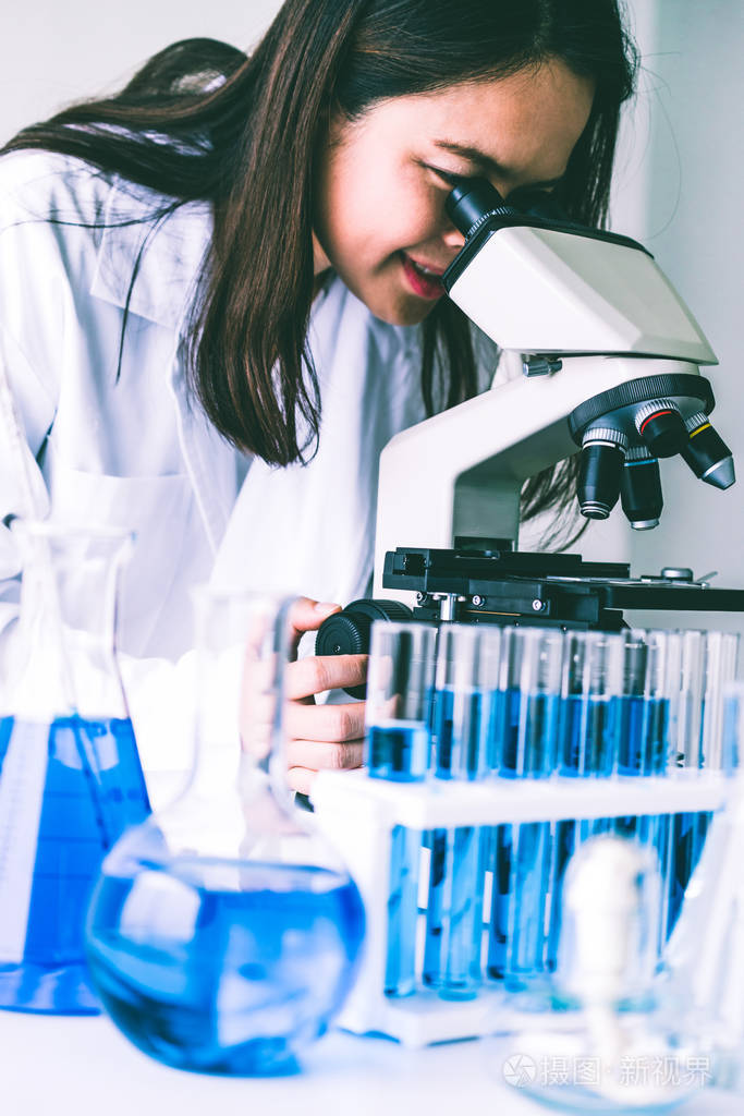 女科学家在实验室工作,检查试管中的生物化学样品.