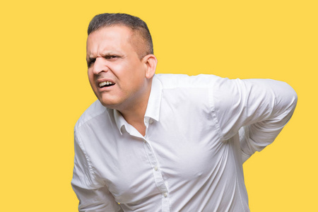 中年阿拉伯优雅的男人,在孤立的背景下,腰酸背痛,手背肌肉疼痛照片