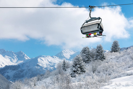 滑雪者坐在椅子上，在法国阿尔卑斯山美丽的白雪皑皑的冬季景观之上