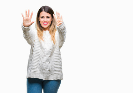年轻漂亮的女人休闲白色毛衣，在孤立的背景上，显示和指向9号手指，同时微笑自信和快乐。