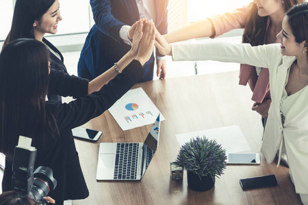 女企业家携手在现代办公室举行小组会议,展示团队合作的支持和团结在