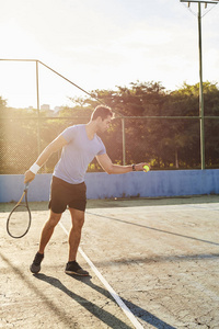 阳光明媚的网球运动员准备发球
