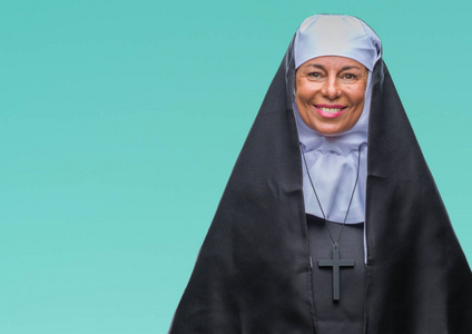 中年高级基督教天主教修女妇女在孤立的背景下,脸上带着快乐和冷静的