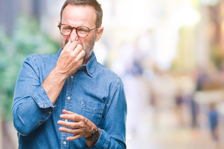 在孤立的背景上闻着一些臭味和恶心的东西,难以忍受的气味,用手指在