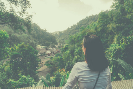 女人冷坐观光自然环境自由的理念。假期放松