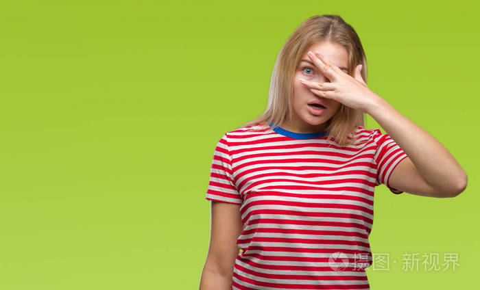 年轻的白种人女人在孤立的背景下用手捂住脸和眼睛用尴尬的表情透过