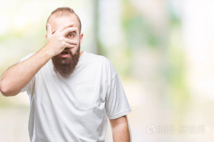 在孤立的背景上偷看,震惊地遮住脸和眼睛,用手透过手指看着尴尬的表情