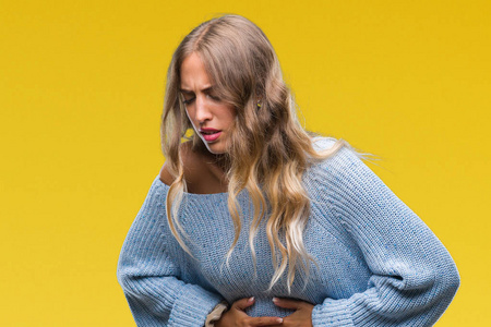 美丽的年轻金发女人穿着冬天的毛衣,在孤立的背景上,手放在肚子上