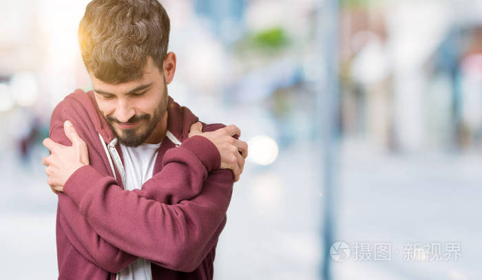 年轻英俊的男人越过孤立的背景拥抱自己快乐和积极,微笑自信.自我爱和