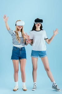 穿着蓝色背景的VR耳机摆姿势的兴奋女孩