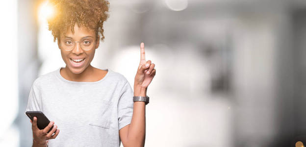 年轻的非洲裔美国妇女使用智能手机，在孤立的背景下惊讶地发现了一个想法或问题，手指着快乐的脸第一