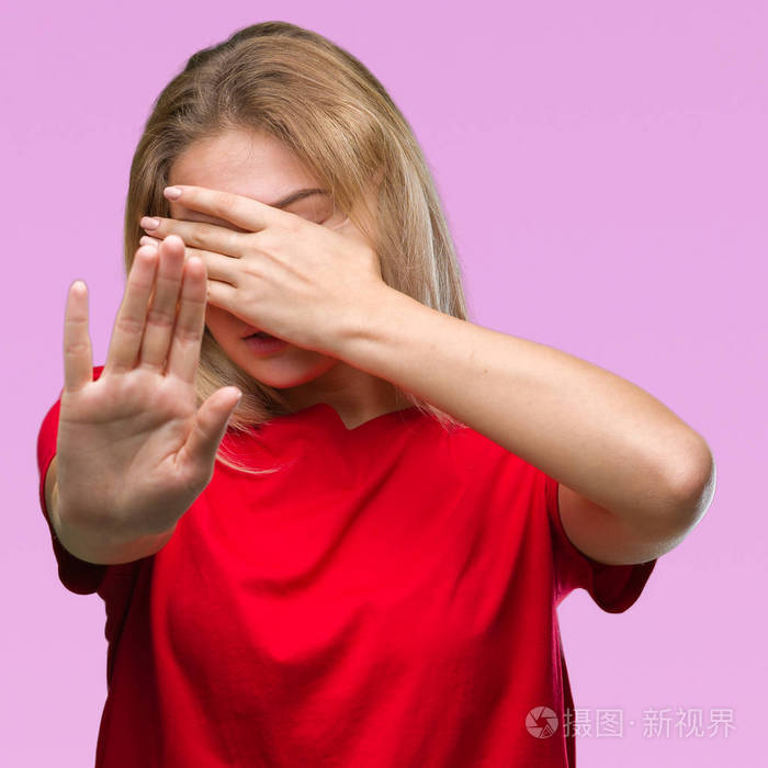 年轻的高加索女人在孤立的背景上用手遮住眼睛,用悲伤和恐惧的表情做