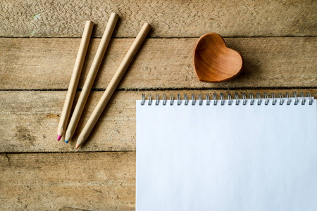 木制桌子上的铅笔和笔记本。