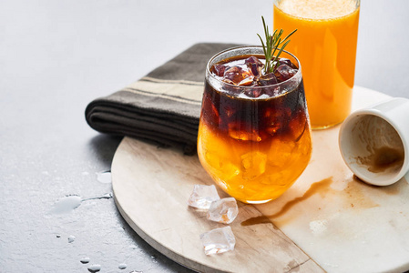 橙汁浓缩咖啡与冰瓶有机橙汁和空浓缩咖啡拍摄在白色大理石上的盘子