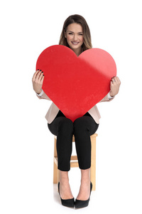 s day heart while sitting on wooden stool on white background
