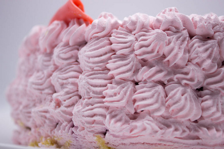 盘子上装饰着奶油的粉红色蛋糕