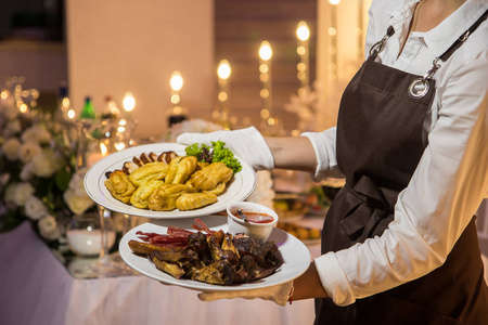 watoast女服务员端着两盘肉菜. 餐饮服务照片